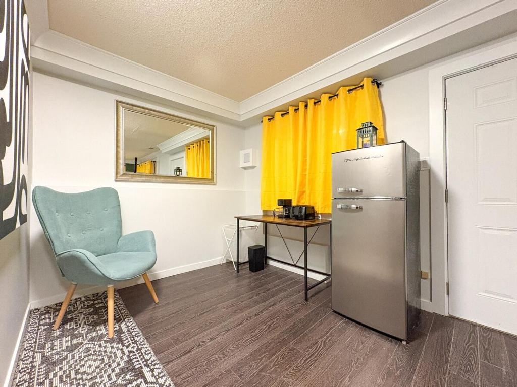 a room with a refrigerator and a chair and a table at Vancouver UBC 2BD Suite in Vancouver