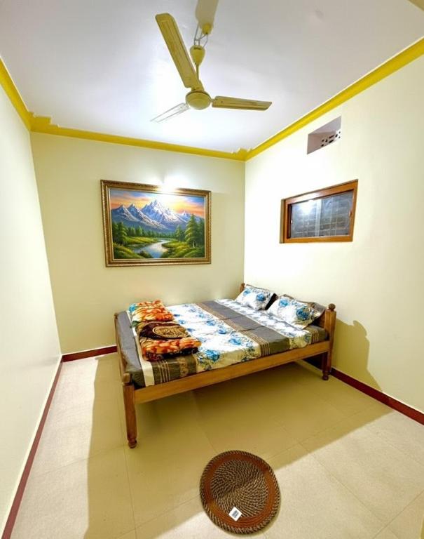 a bed in a room with a ceiling fan at Koraput Crown Homestay in Similigurha