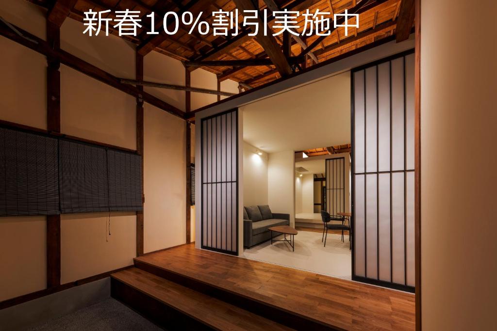 een kamer met glazen deuren en een woonkamer bij Miharaya Setoda in Onomichi
