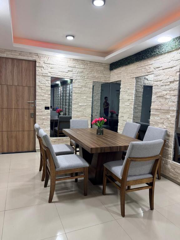 a dining room with a wooden table and chairs at Hermoso Departamento Moderno con alberca in Boca del Río
