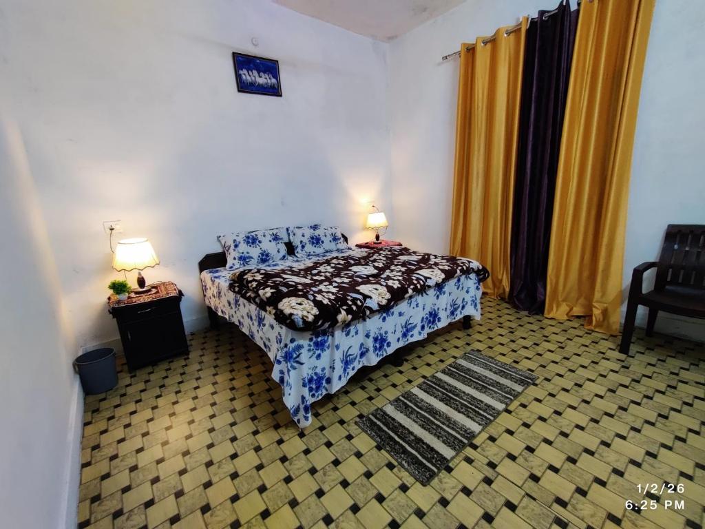 a bedroom with a bed and two lamps in it at MK Devbhoomi Homestay in Kandikhal