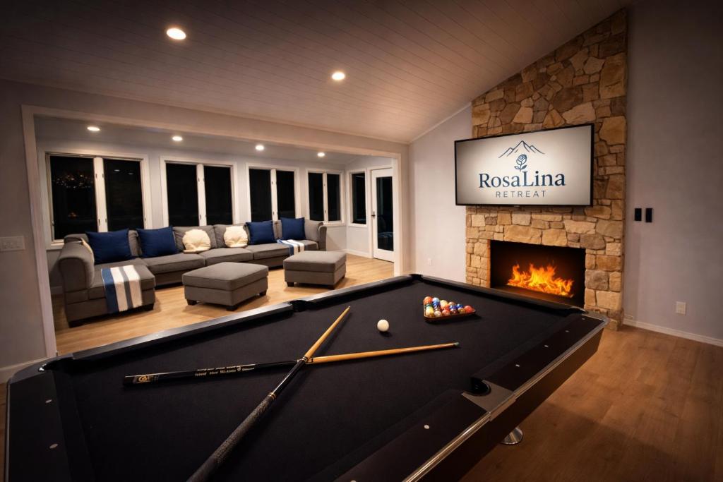a pool table in a living room with a fireplace at RosaLina Retreat in McGaheysville