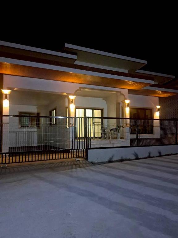 a white building with lights on it at night at Bancha white house in Ban Bo Han