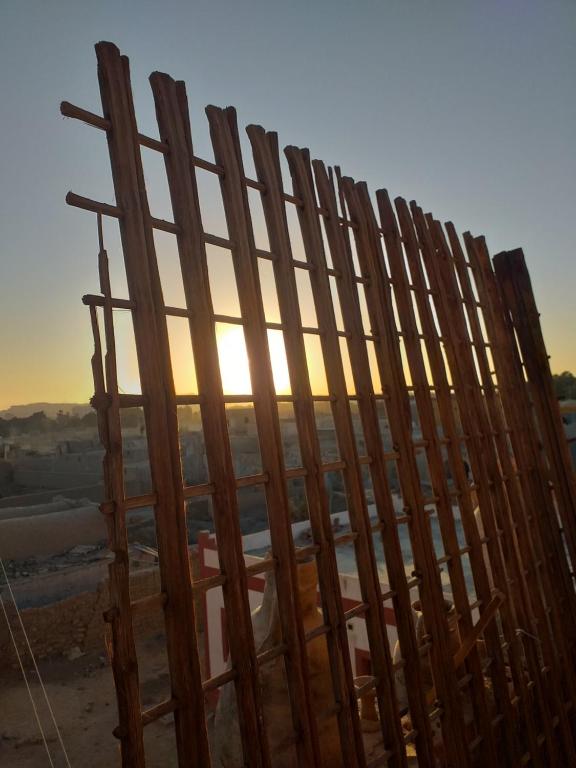een houten hek met de zonsondergang op de achtergrond bij Mourad morsy مراد in Najâ€˜ al MadÄbb