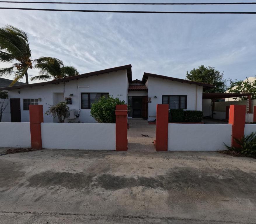 a house with white walls and a palm tree at Palm Beach 278 in Palm-Eagle Beach