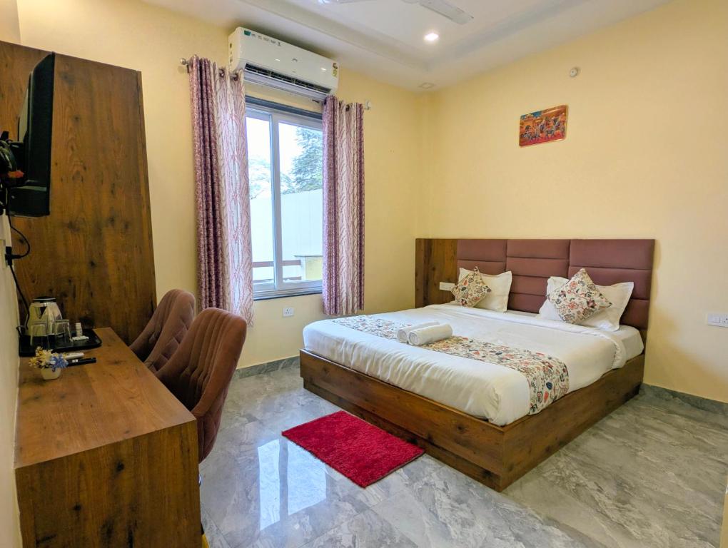 a bedroom with a bed and a desk and a window at Ganga Yamuna View in Prayagraj