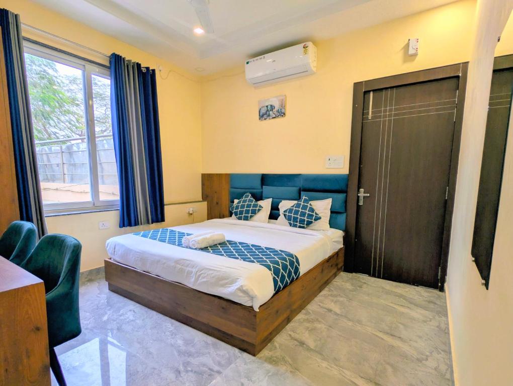 a bedroom with a bed with blue pillows at Ganga Yamuna View in Prayagraj