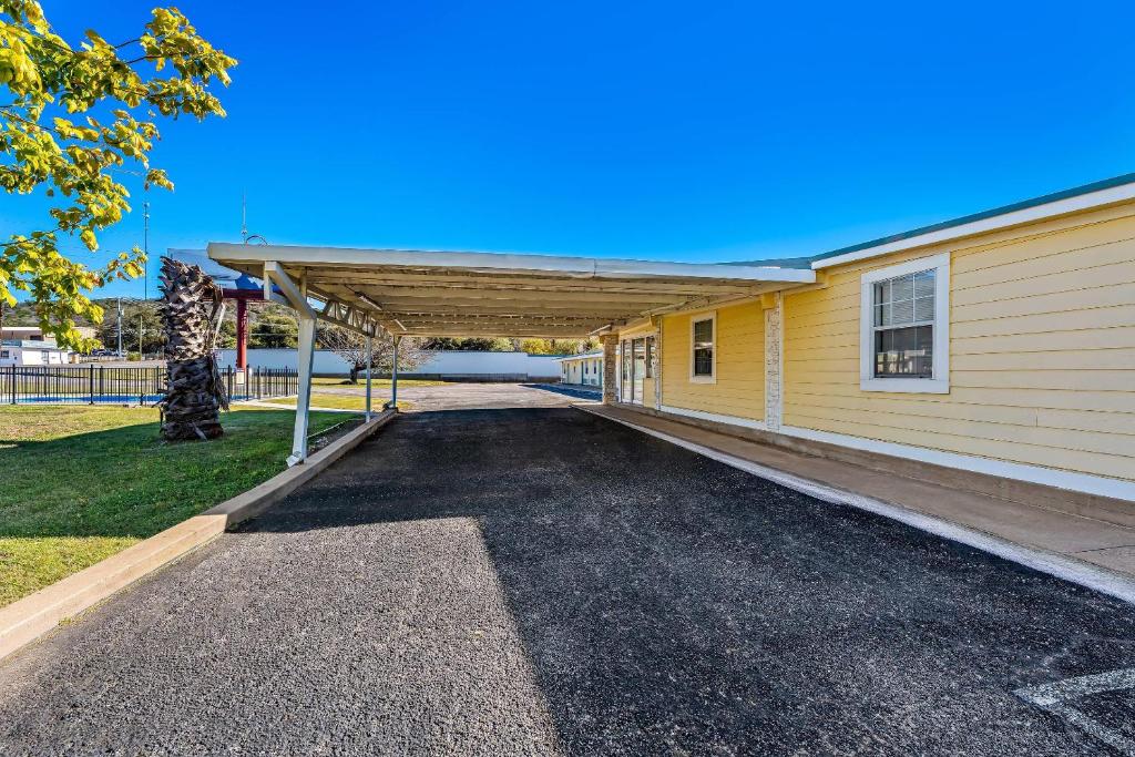 un parcheggio di fronte a un edificio giallo di Rodeway Inn Kingsland - Lake LBJ a Kingsland