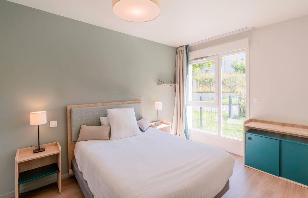 Un pat sau paturi într-o cameră la Quality Aparthotel Limoges