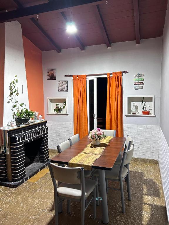 een eetkamer met een tafel en een open haard bij Departamento Zoe in La Falda