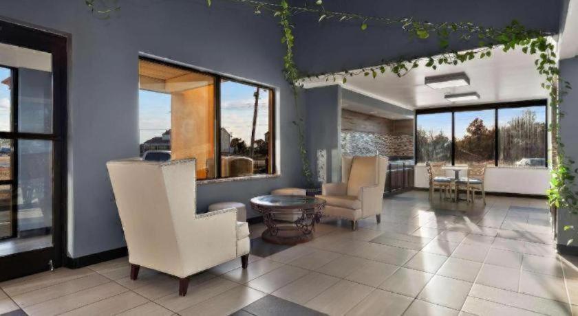 een woonkamer met witte meubels en grote ramen bij Rodeway Inn Lumberton Central in Lumberton