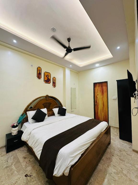 a bedroom with a large bed with a ceiling fan at Hotel Castle in Indore