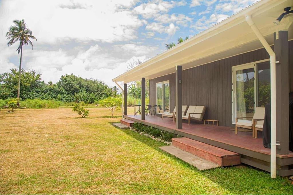 a house with a porch with chairs on it at 2 Bedroom House - Villa Teremoana in Ngatangiia