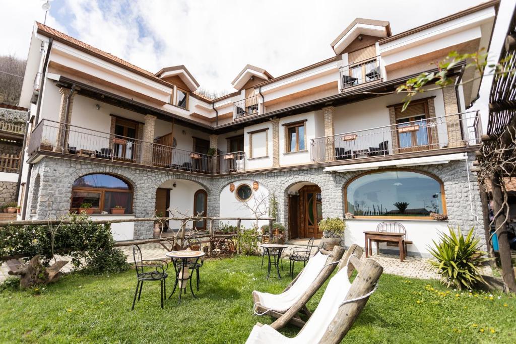 ein Haus mit einem Garten mit Stühlen und Tischen in der Unterkunft Villa Italia in Agerola