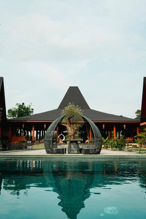 a swimming pool with a sculpture in front of a building at Acasa Cottage by Samsara in Cipaok