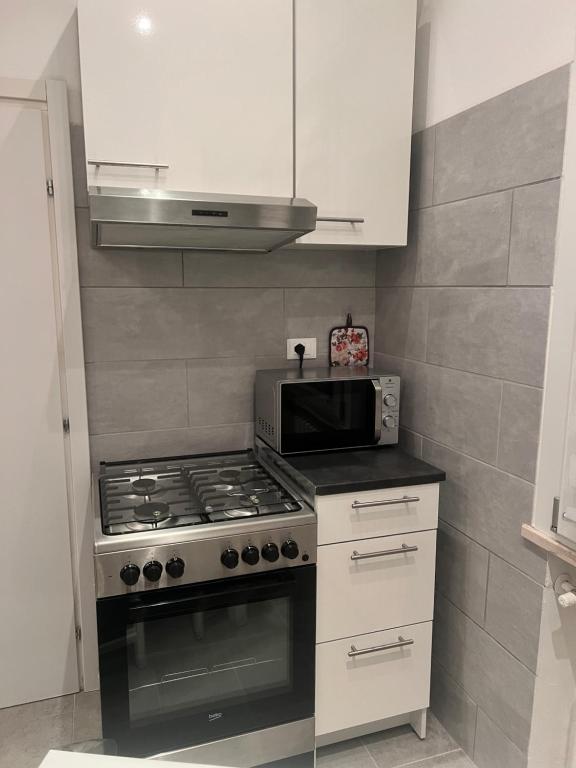 a kitchen with a stove and a microwave at SantegidioHomeCesena in Cesena