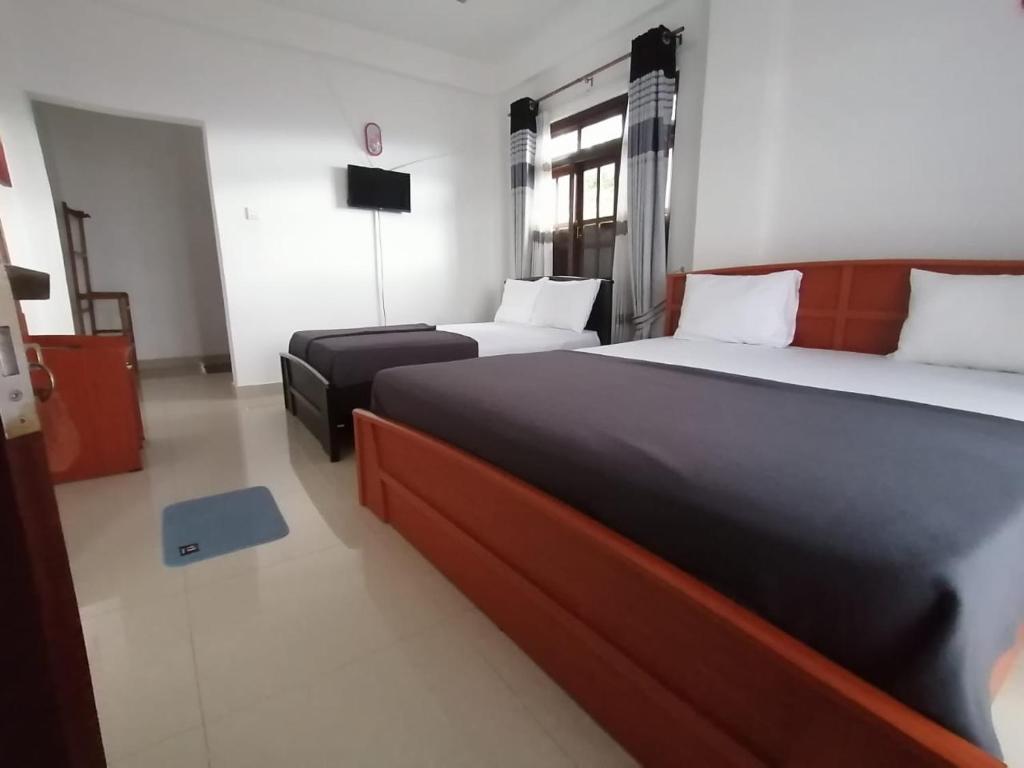 a hotel room with two beds and a television at Mystik Muthu View Haputale in Haputale