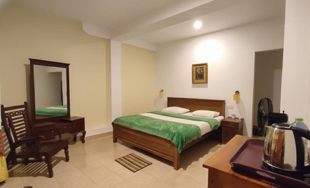 a bedroom with a bed and a desk and a mirror at Blue sky Guest House And Restaurant in Adams Peak