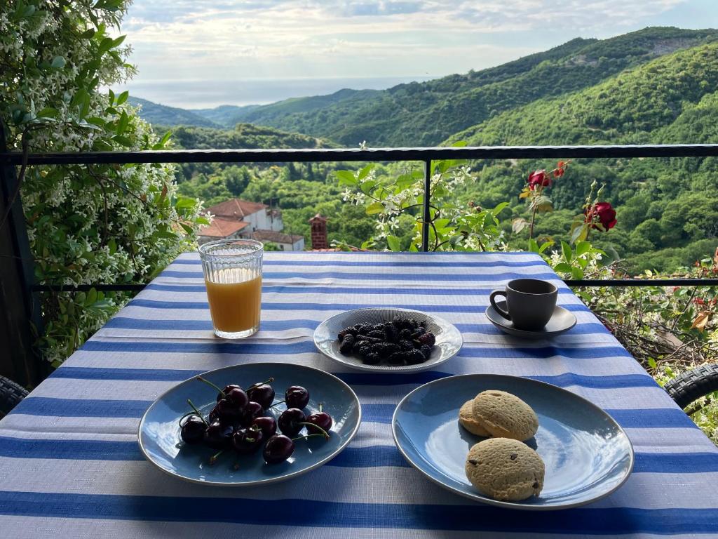 una tavola con piatti di cibo e un bicchiere di succo d'arancia di Melivista a Melívoia