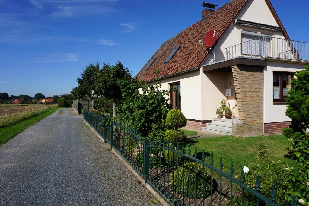 a house with a fence next to a road at Ferienwohnung Grimmelmann in Eystrup