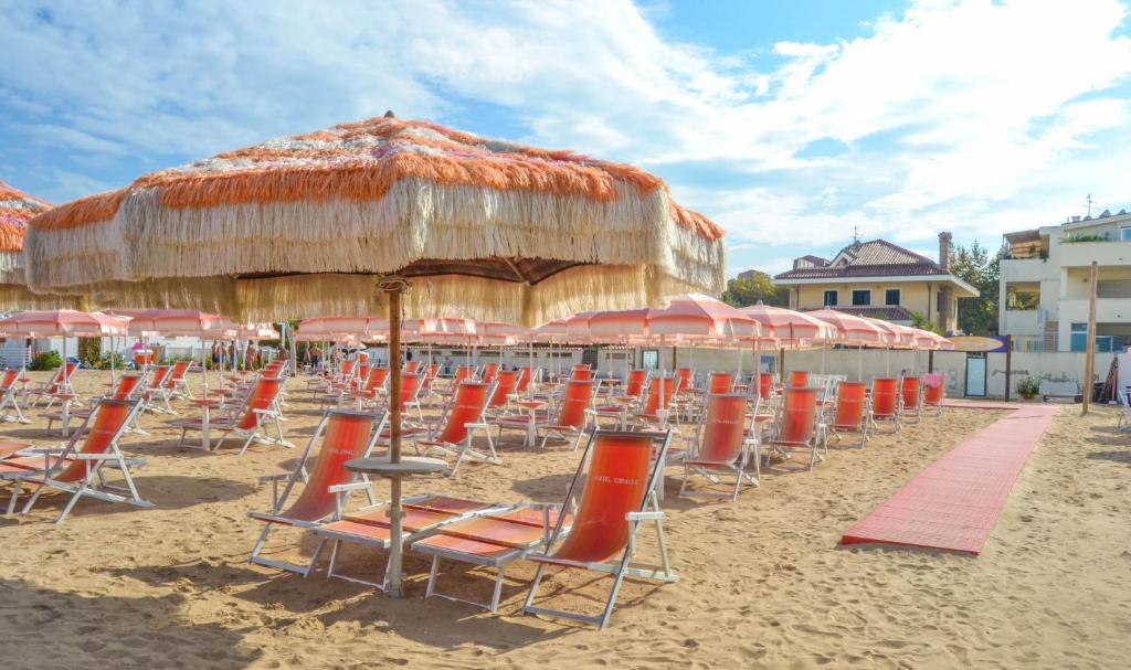 a bunch of chairs and umbrellas on a beach at Hotel Corallo in Francavilla al Mare
