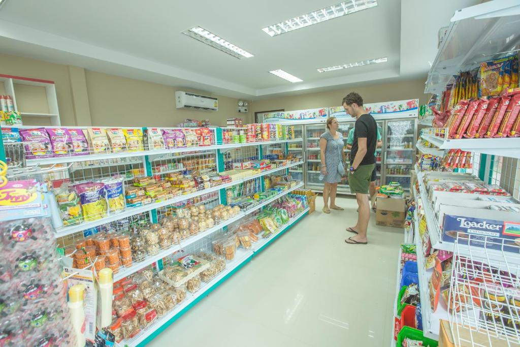 Un uomo e una donna in piedi in un corridoio di un supermercato di Phi Phi Andaman Beach Resort a Phi Phi Don