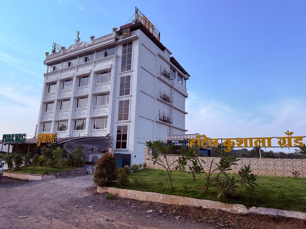 ein weißes Gebäude mit einem Schild an der Seite in der Unterkunft Hotel Kushala Grand, Dombivali in Mangrul