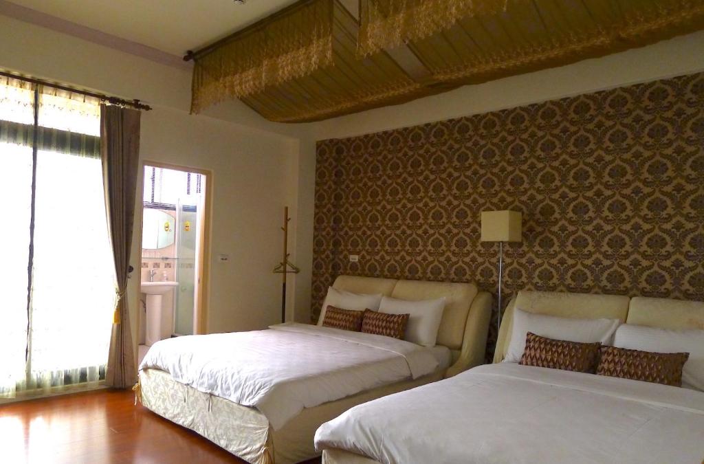 a bedroom with two beds and a large window at Amicasa Guesthouse in Hualien City