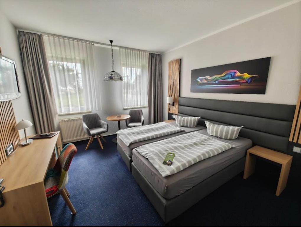 a hotel room with two beds and a desk at Turmhotel Schwedt in Schwedt