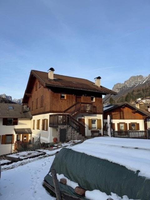 a large wooden house with snow on the ground at Casa di Lilly in Moena