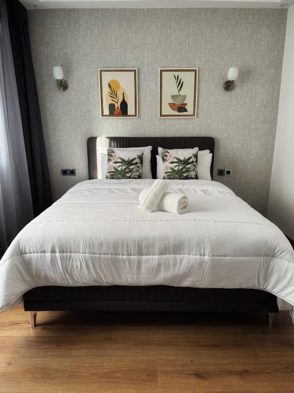 een slaapkamer met een groot wit bed met twee kussens bij HOME RABAT Hassan in Rabat