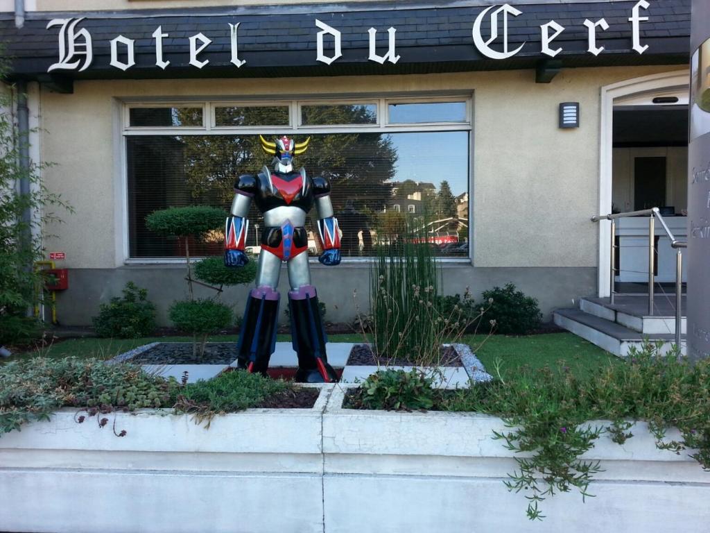 a statue of a superhero in front of a building at Contact Hôtel du Cerf in Château-Gontier