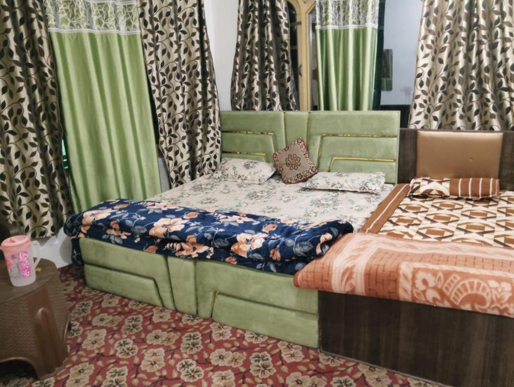 a bedroom with two beds and curtains and a bed sidx sidx sidx at Kashmir naaz in Srinagar