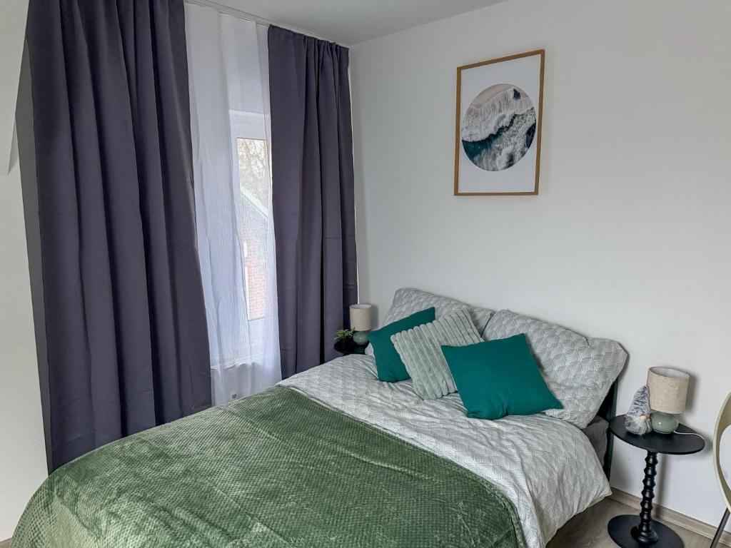 a bedroom with a bed with green sheets and a window at Apartments Brunsbüttel in Brunsbüttel
