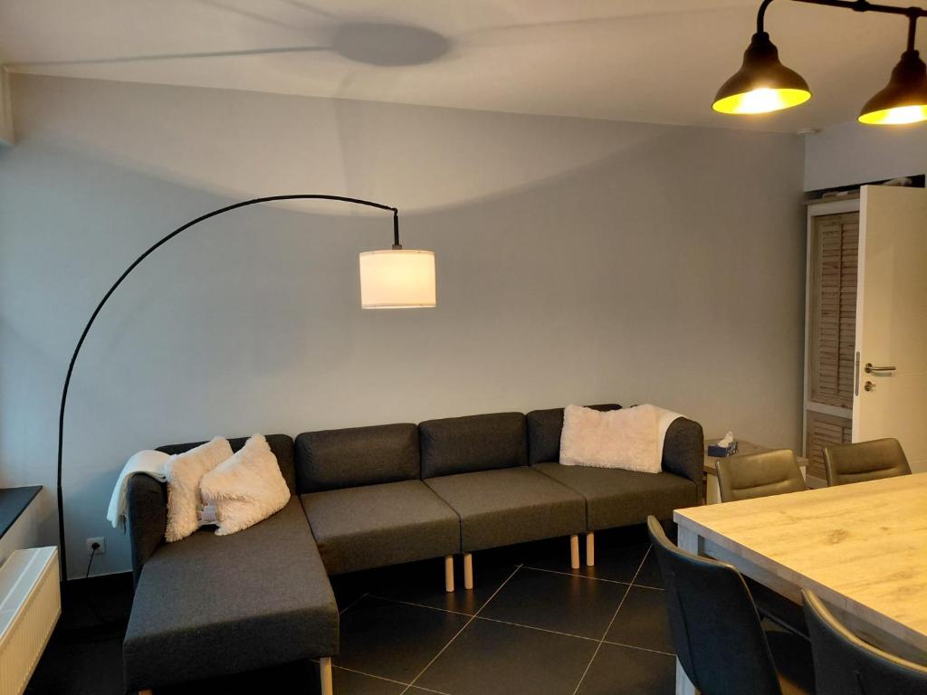 a living room with a couch and a table at App ZeeVorm Nieuw in De Panne