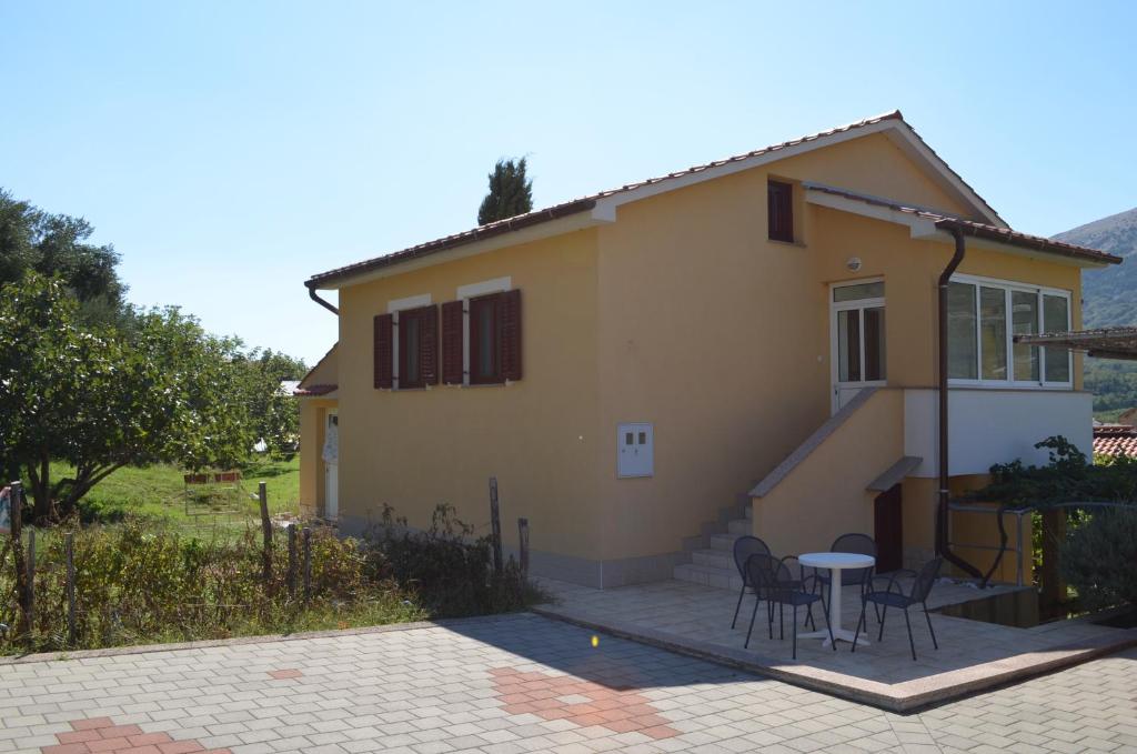 ein Haus mit Stühlen und einem Tisch davor in der Unterkunft Apartments Elizabeta in Draga Bašćanska