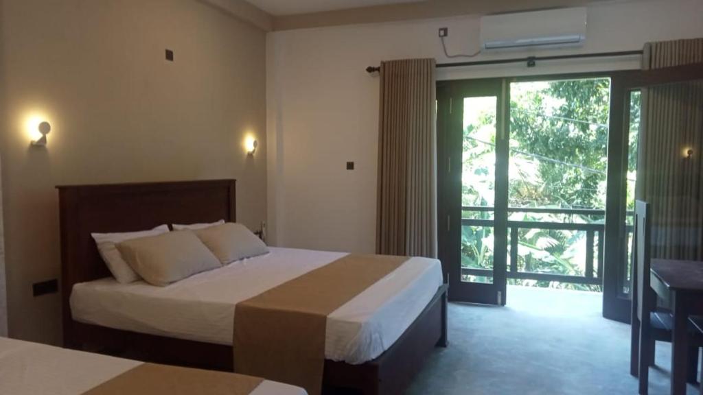 a hotel room with a bed and a sliding glass door at Opara Palace in Weligama