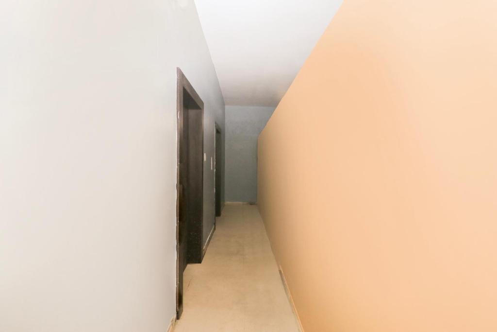 an empty corridor with a door in a white wall at Hotel O by OYO Rajveer Hotel in Rāmgarh