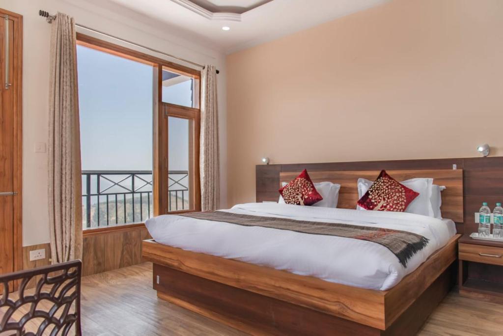 a bedroom with a large bed and a large window at Baldeyan Breeze - 2BHK Apartments - Private Balcony in Shimla