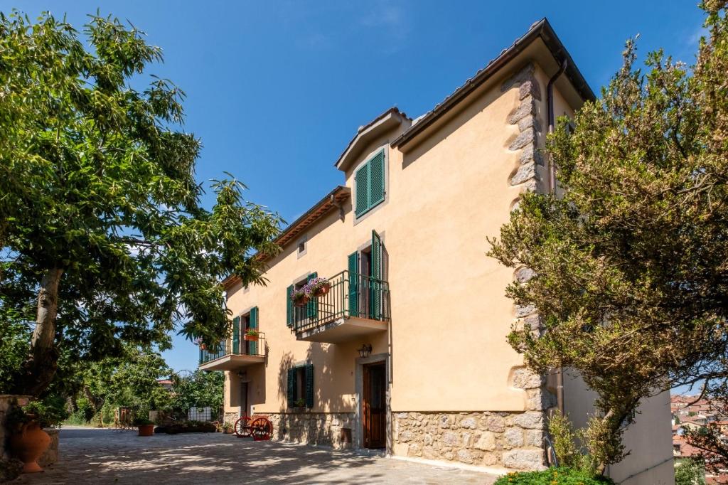 an apartment building with a balcony and trees at le stanze della Terrazza sul Borgo in Castel del Piano