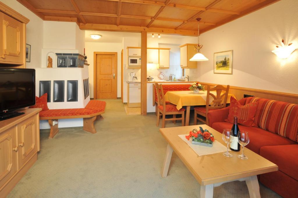 ein Wohnzimmer mit einem Sofa und einem Tisch in der Unterkunft Ferienwohnungen am Hausberg in Reit im Winkl