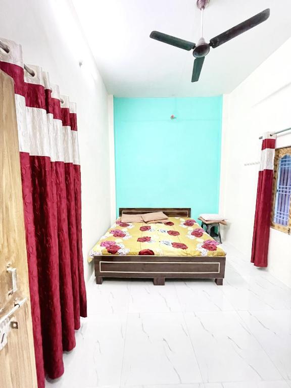 a bedroom with a bed and red curtains at Bajrang kutir B in Varanasi