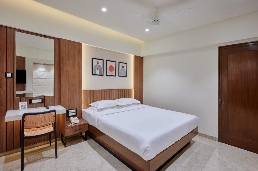 a bedroom with a bed and a desk and a mirror at Hotel Karl Residency in Mumbai