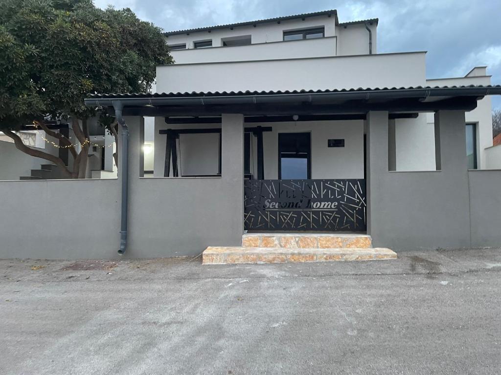 a white building with a sign on the front of it at Second home apartment - rose gold in Kustići