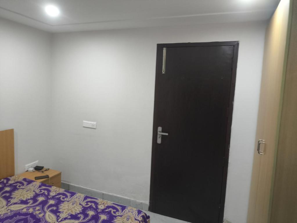 a black door in a room with a bed at Chandigarh city centre in Zirakpur