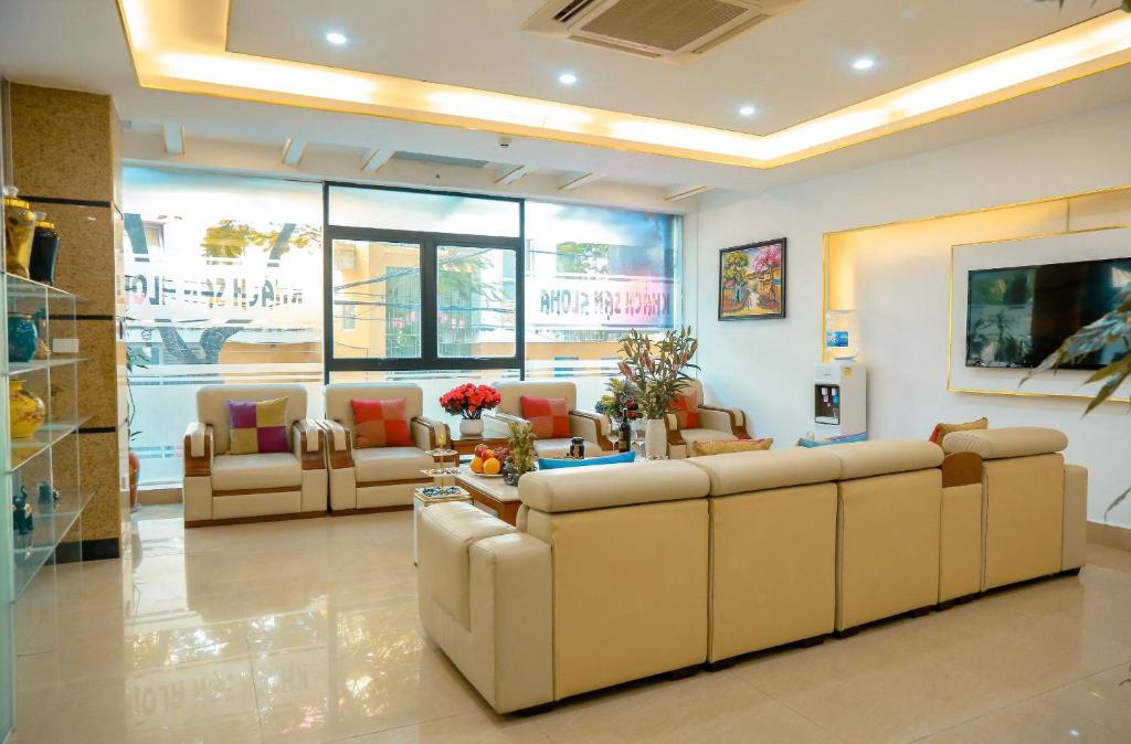 a waiting room with couches and tables in a building at khách sạn Aloha in Hanoi