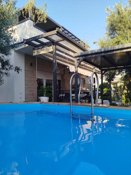 a swimming pool in front of a house at Luxury Apartment Slavica in Vodice