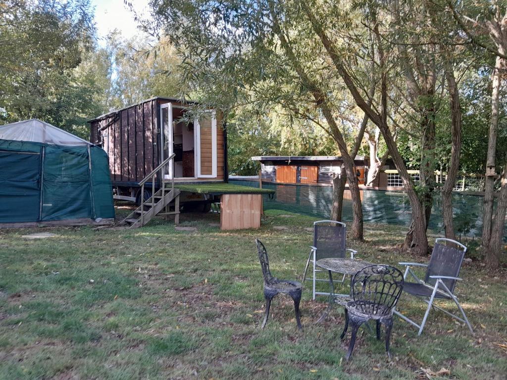 two chairs and a table in a yard with a tent at Sleep-in Beauty in Thakeham