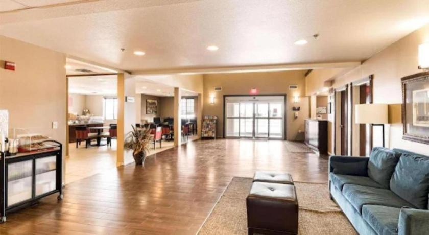 un ampio soggiorno con divano blu e cucina di Hawthorn Extended Stay by Wyndham Amarillo a Soncy