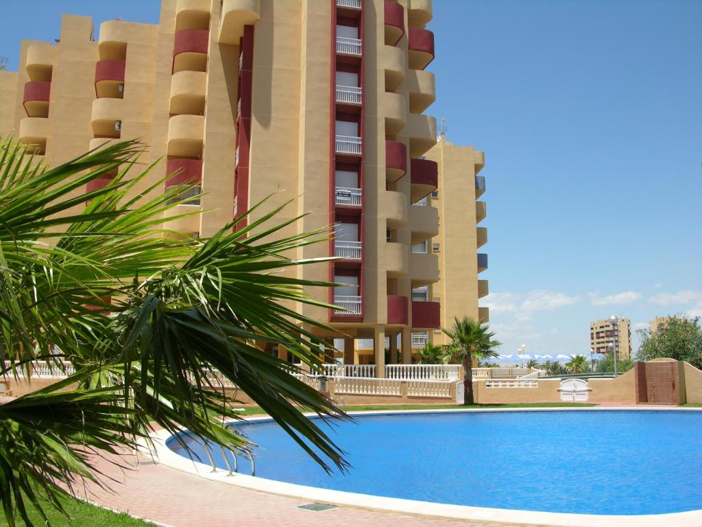 uma piscina em frente a um grande edifício em Los Miradores Del Puerto - 5207 em La Manga del Mar Menor